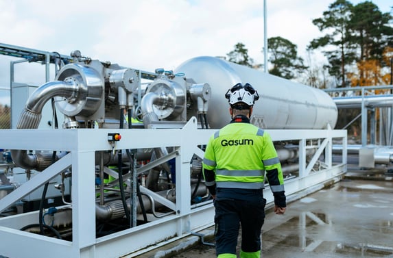 person walking at a biogas plant with work jacket that says Gasum