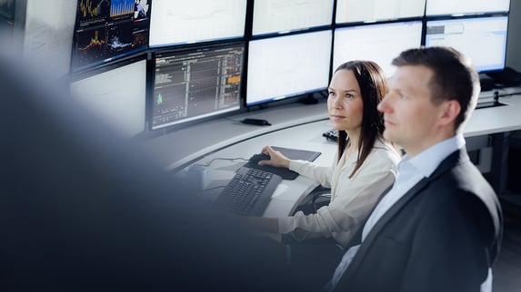 two people looking at a computer and analysing